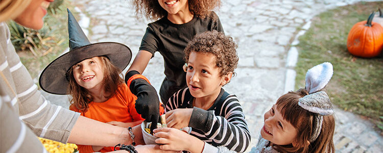 Children in halloween costumes trick or treating for a blog on how to prepare for Halloween