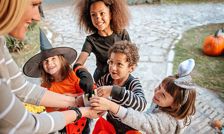 Children in halloween costumes trick or treating for a blog on how to prepare for Halloween